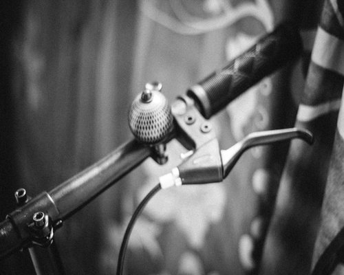 Close up of a bicycle handlebar with a mounted front light and a bell