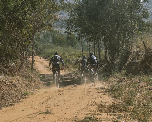 Group of cyclists on a dirt road exploring a natural trail near a Mexican town